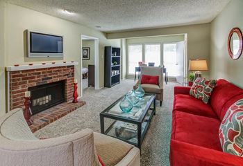 Living room with brick fireplace and television